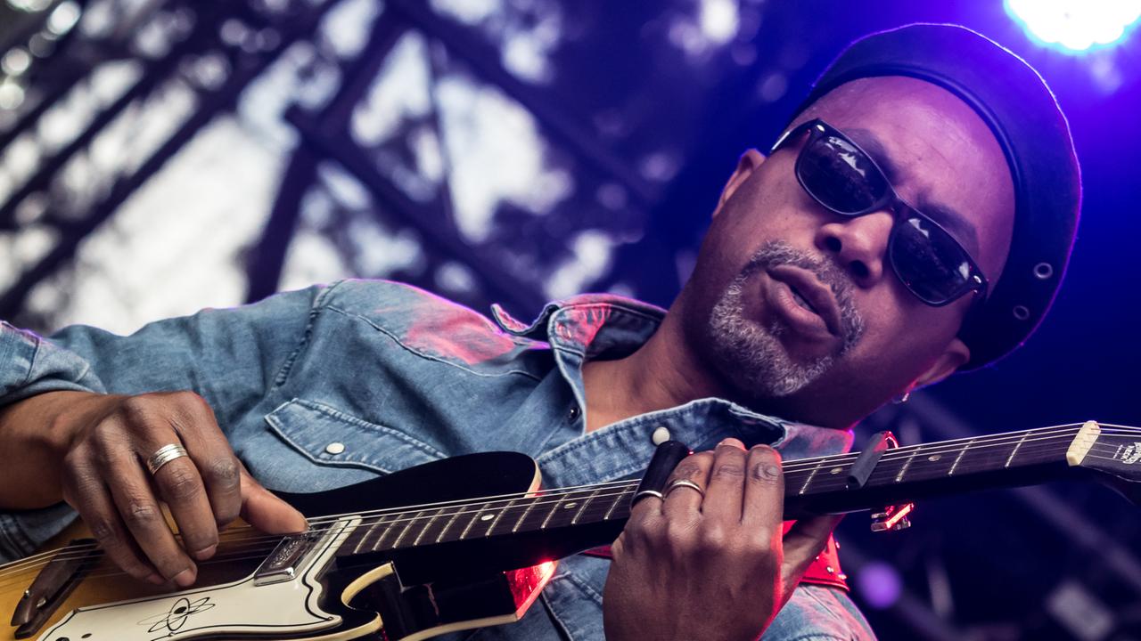 Ein Mann mit Sonnenbrille spielt auf einer Gitarre.