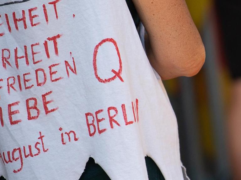 Eine Frau trägt während einer Kundgebung der Initiative «Querdenken 711» im unteren Schlossgarten, die sich gegen die Corona-Maßnahmen richtet, ein Shirt mit der Aufschrift «Freiheit, Wahrheit, Frieden & Liebe» sowie «Q».