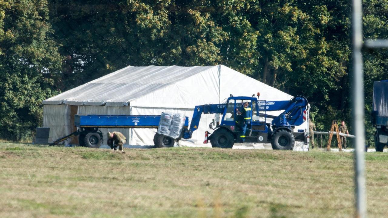 THW-Helfer und Bundeswehrsoldaten bauen auf einem Gelände in Feldkirchen nahe Straubing im September 2015 Zelte auf.