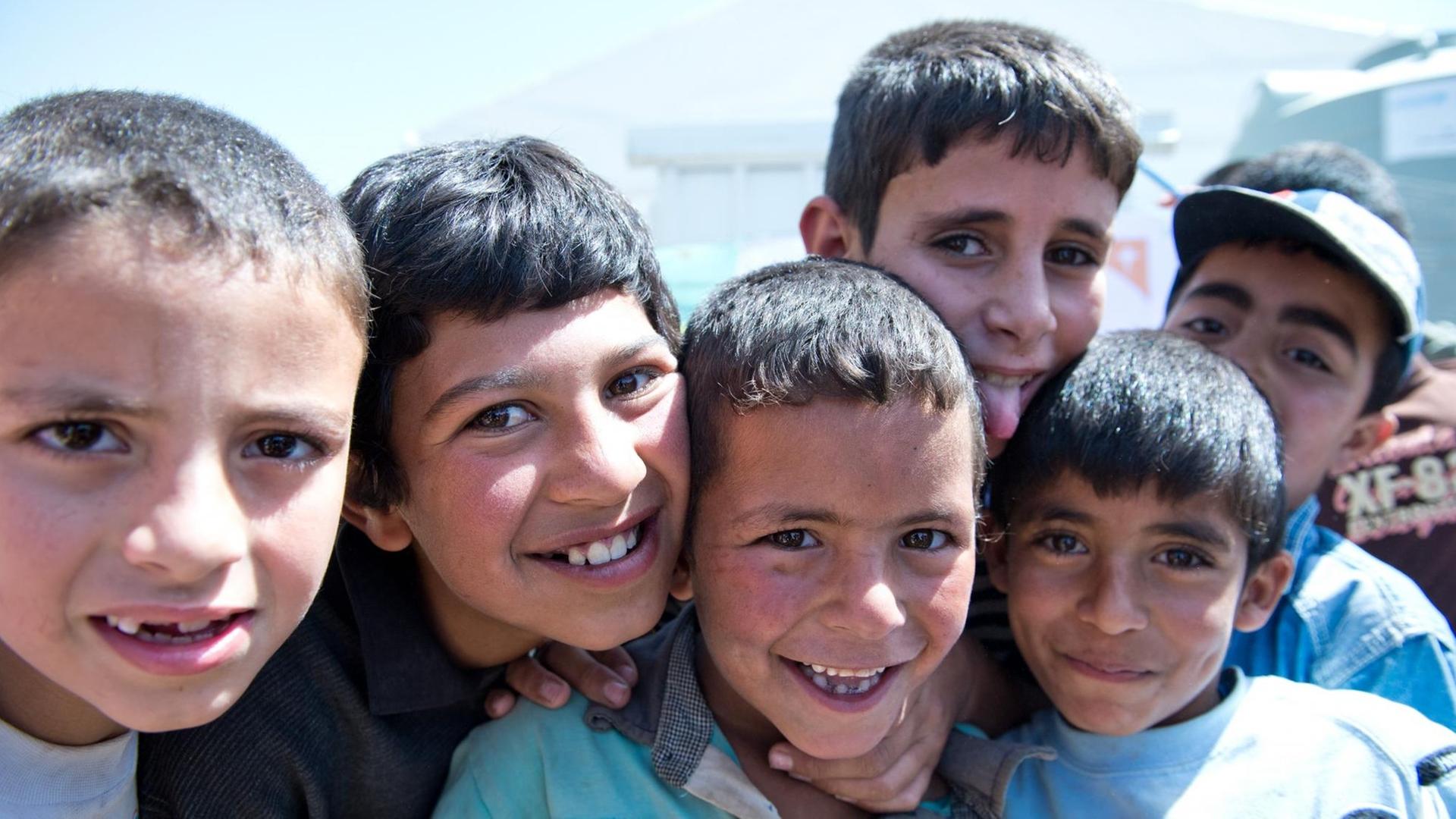 Flüchtlingskinder aus Syrien lachen am 30.05.2014 in Barr Elias (Libanon) in einem Lager für Flüchtlinge aus Syrien. Außenminister Steinmeier ist bis Sonntag zu Gesprächen über den Syrien-Konflikt im Libanon, den Vereinigten Arabischen Emiraten und Katar.