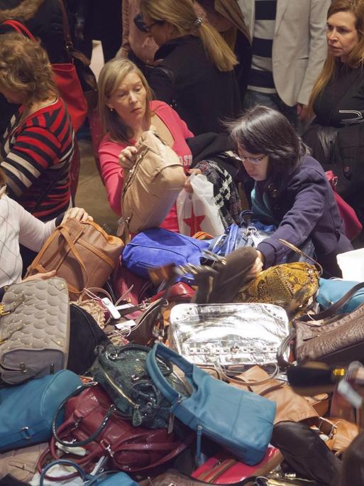 Einige Damen wühlen in einem bunten Handtaschenberg bei Macy´s in New York.