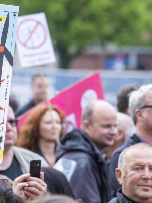 Demonstranten tragen Protestschilder gegen den Bau zusätzlicher Windkraftanlagen.