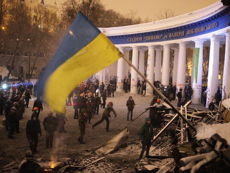 Ukrainische Oppositionelle versammeln sich vor einer Barrikade im Zentrum der Hauptstadt Kiew.