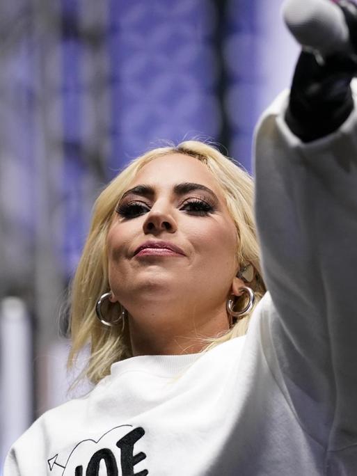 Lady Gaga trat im Novembe 2020, kurz vor der Präsidentenwahl, bei einer Wahlkampfveranstaltung für Joe Biden in Pittsburgh auf. Sie trägt ein weißes Sweatshirt mit der Aufschrift Joe und hält ihr Mikro in Richtung Publikum.
