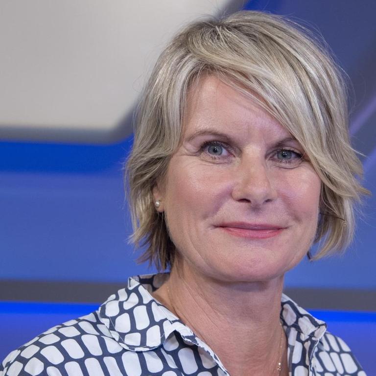 Eine Frau mit halblangen blonden Haaren sitzt in einem TV-Studio.