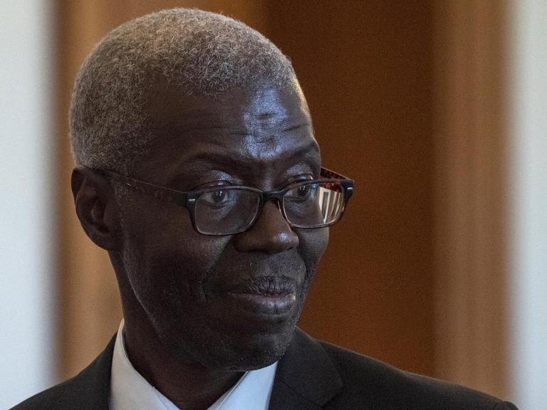 Der senegalesische Philosoph Souleymane Bachir Diagne wird, vor einem Treffen mit Frank-Walter Steinmeierin Berlin, im Präsidentenpalast herumgeführt.