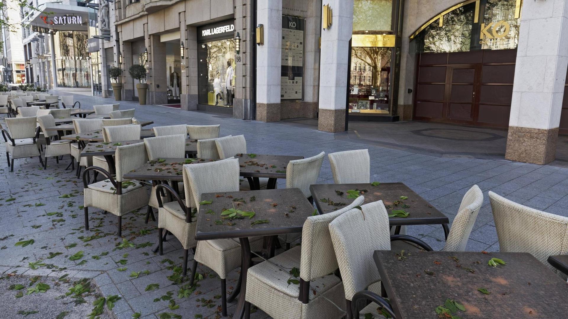 Leere Stühle eines Cafés auf der Königsallee in Düsseldorf.