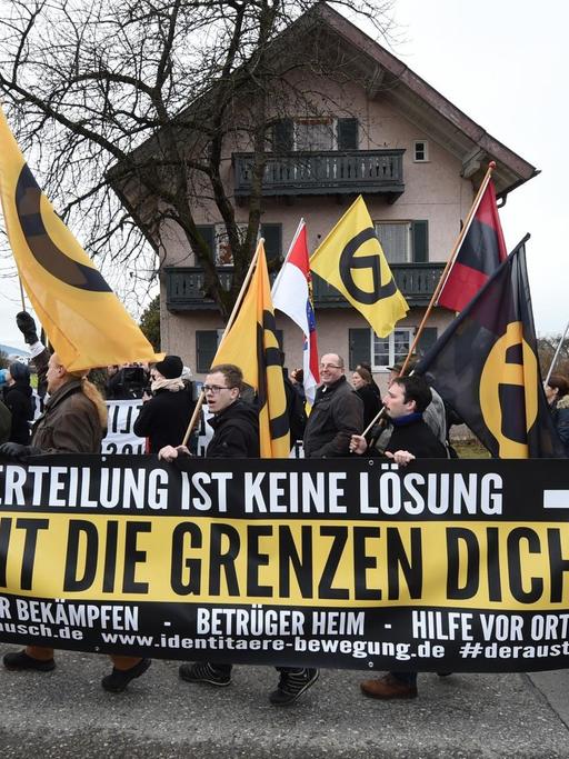 Demonstranten tragen am 09.01.2016 bei Freilassing (Bayern) bei einer Kundgebung ein Transparent mit der Aufschrift "Verteilung ist keine Lösung macht die Grenzen dicht!".