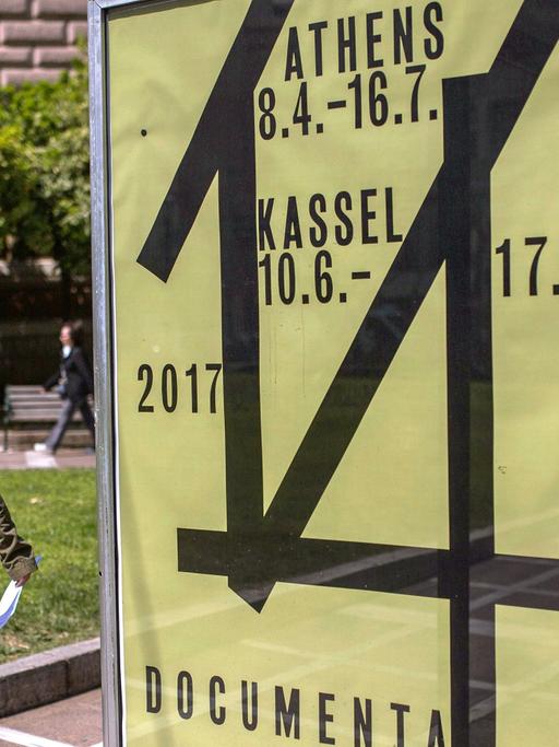Eine Frau geht am 07.04.2017 in Athen (Griechenland) an einem Werbeplakat für die documenta 14 vorbei. Die internationale Kunstausstellung documenta 14 wird erstmals vom 08. April bis 16. Juli 2017 zunächst in Athen und vom 10. Juni bis zum 17. September 2017 in Kassel zu sehen sein.