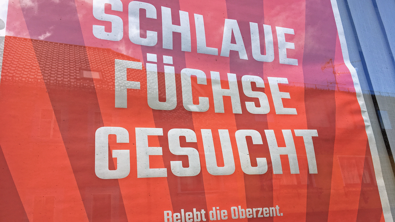 Ein orange-rotes Werbeplakat mit der Aufschrift "Schlaue Füchse gesucht - Belebt die Oberzent."
