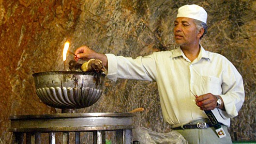Ein Anhänger der zoroastrischen Religion entzündet eine Flamme in einem iranischen Tempel.