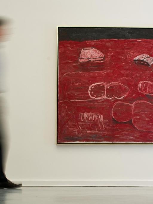 Ein Besucher der Austellung des US-amerikanischen Künstlers Philip Guston geht am 30.04.2014 an dem Gemälde "The Light" (1975) des Künstlers in der Galerie Aurel Scheibler in Berlin vorbei.