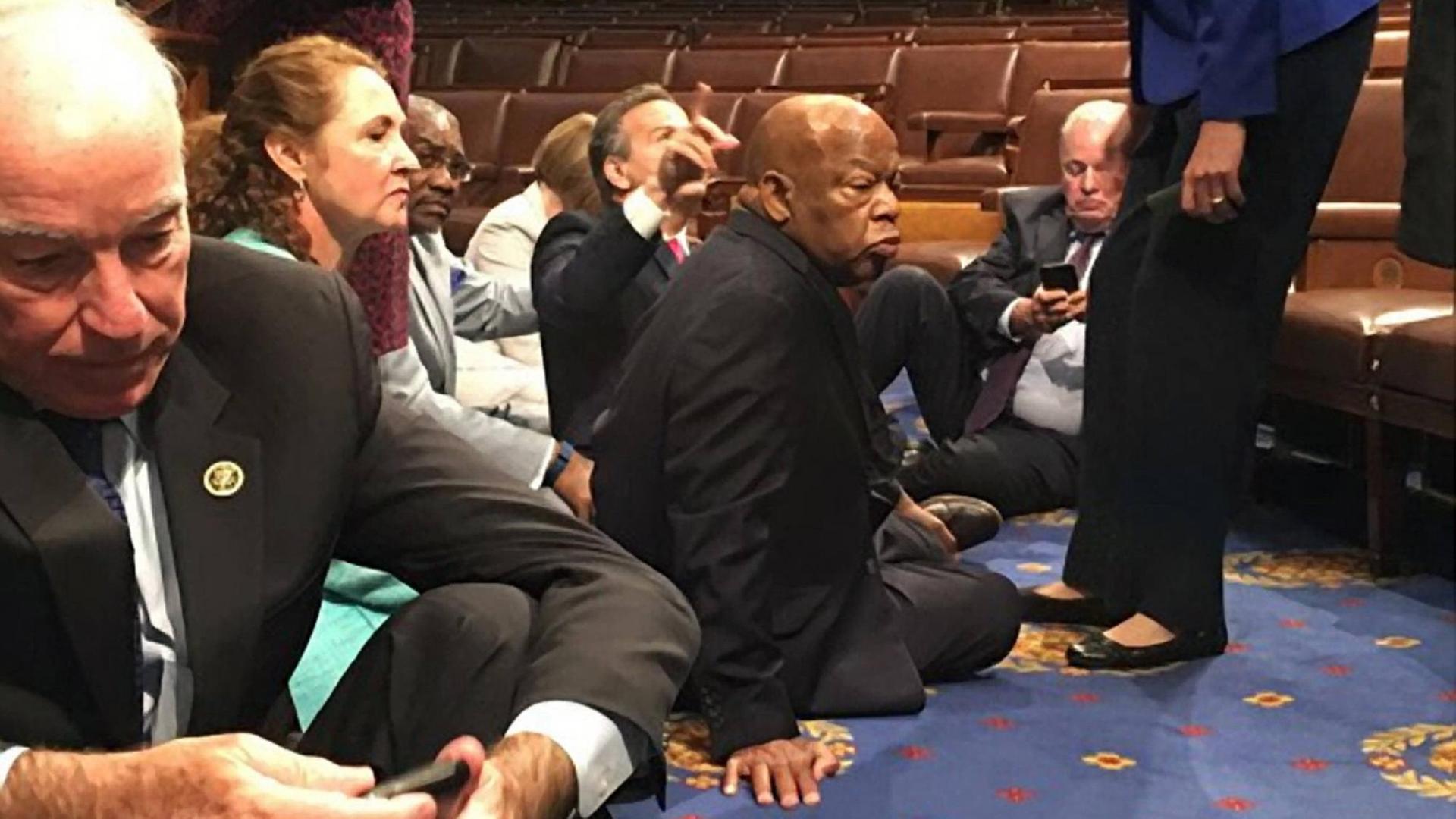 Abgeordnete der Demokraten sitzen auf dem Boden des US-Repräsentantenhauses.