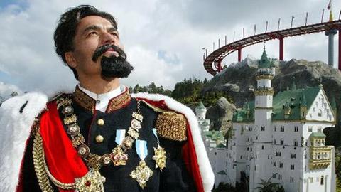 König Ludwig II., im Hintergrund eine Nachbildung von Schloss Neuschwanstein König Ludwig II., im Hintergrund eine Nachbildung von Schloss Neuschwanstein