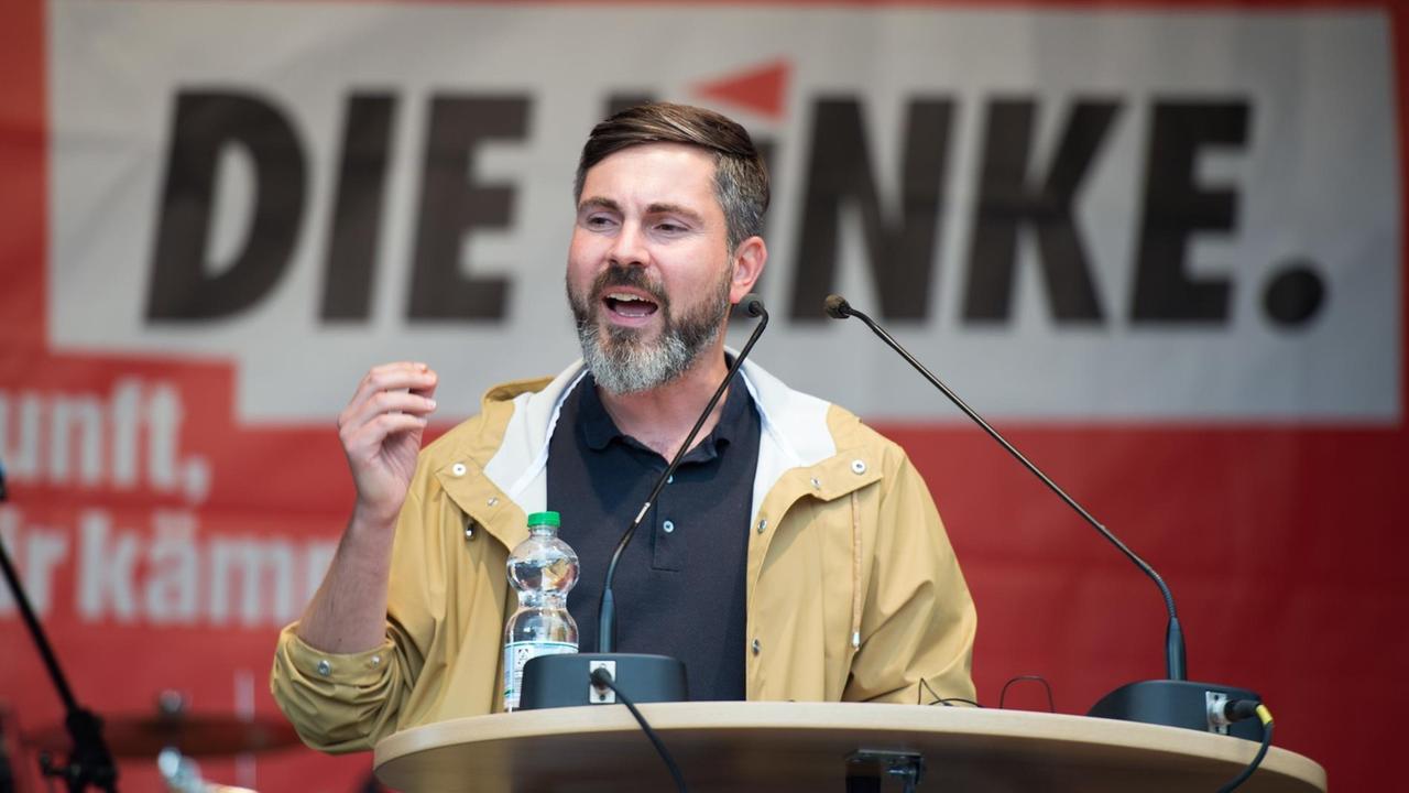 Der Spitzenkandidat der Linken in Hamburg, Fabio De Masi, spricht am 01.09.2017 auf einer Bühne in Hamburg. Foto: Daniel Reinhardt/dpa | Verwendung weltweit