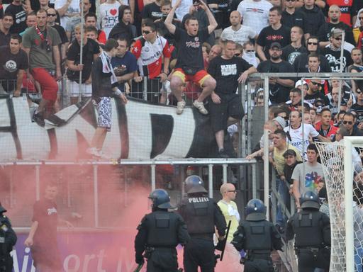 Polizeikräfte gehen nach einem Fußball-Spiel gegen randalierende Fans vor.