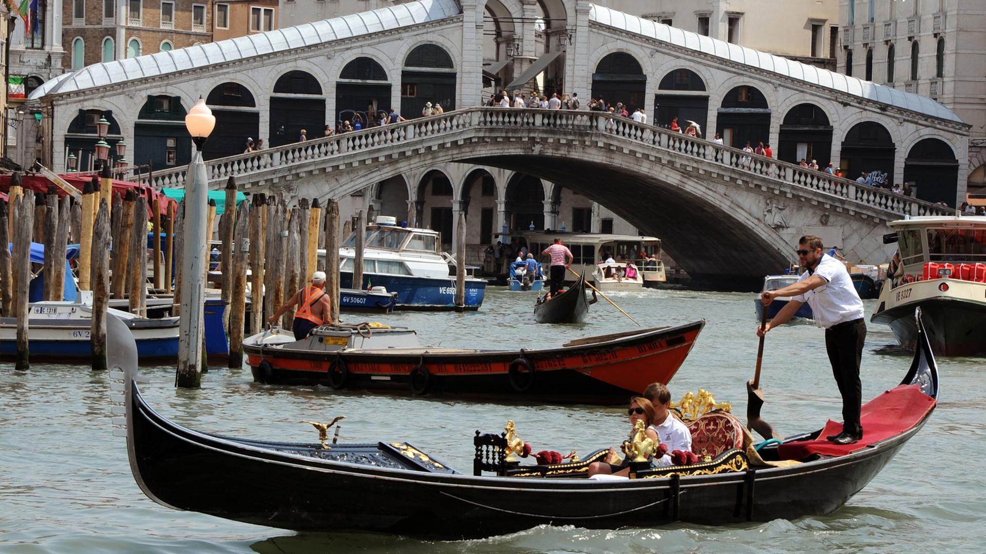 Gondeln, Boote und ein Vaporetto fahren auf dem Canale Grande vor der Rialtobrücke in Venedig