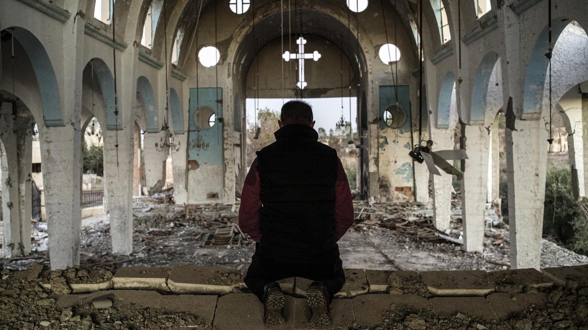 Ein Mann betet in der Kirche St. Georg in der Provinz al-Hasake, die von der Terrororganisation Islamischer Staat zerstört wurde