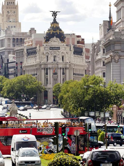 Ein roter Touristenbus an der Prachtstraße Gran Vía und Calle de Alcala in Madrid.