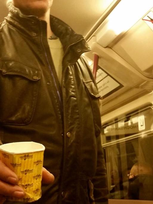 Ein Bettler bittet in einer U-Bahn um eine Geldspende.