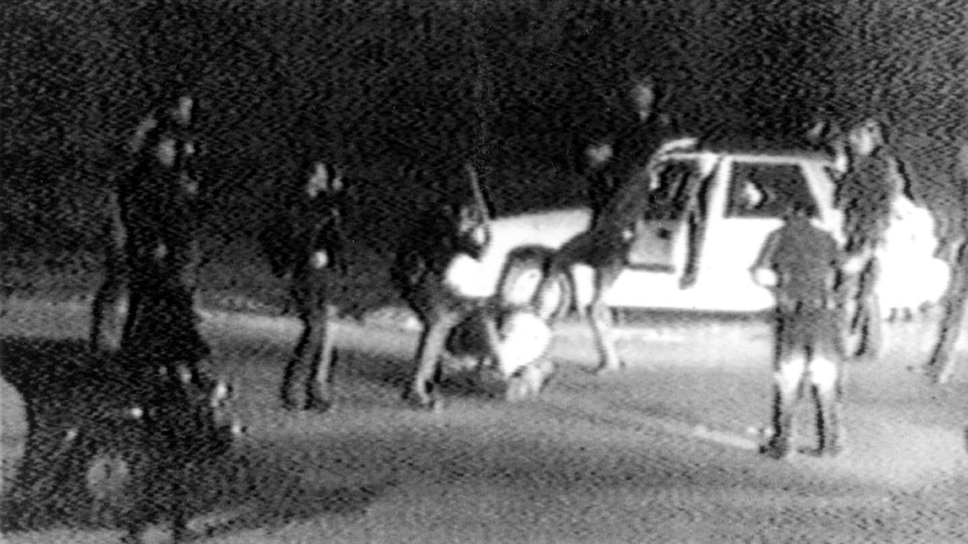Grobkörnige Schwarz-Weiß-Aufnahme: Polizisten schlagen und treten auf einen am Boden liegenden Mann. Es handelt sich um Rodney King.