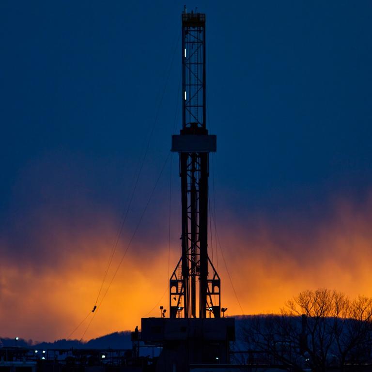 Ein Fracking-Bohrturm in der Abenddämmerung. 