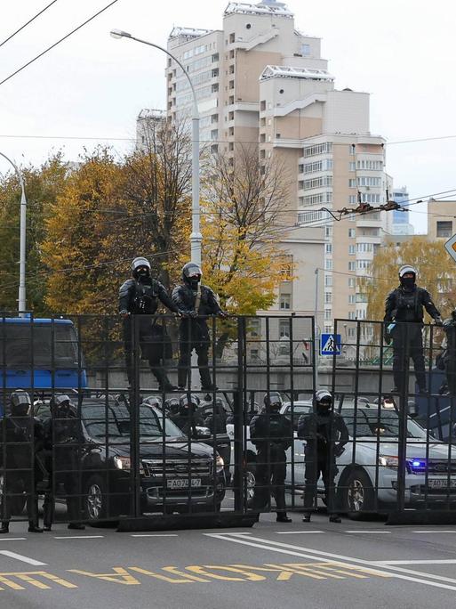 Polizisten haben auf einer Straße in Minsk eine Barrikade errichtet.