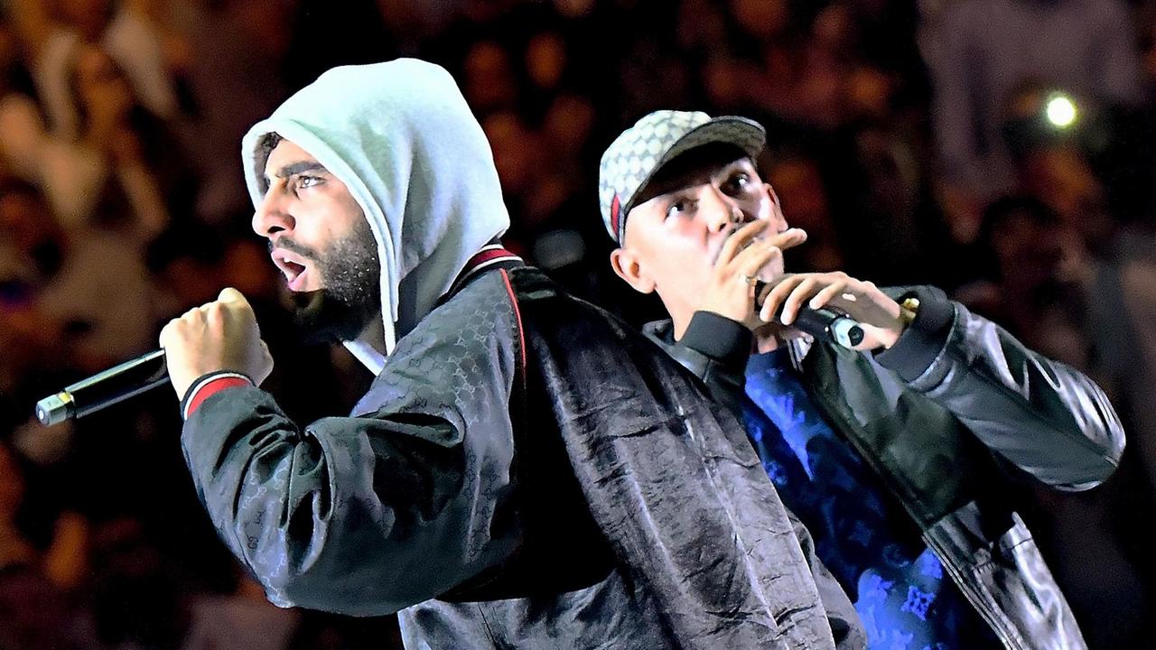 Die Rapper Capital Bra und Samra stehen mit Mikrofon auf der Bühne und performen.