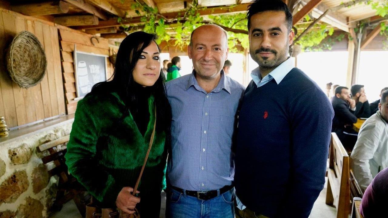 Alp Arson (Mitte) mit zwei Gästen der Pizzeria im Dorf Kafro, nahe der Grenze zu Syrien