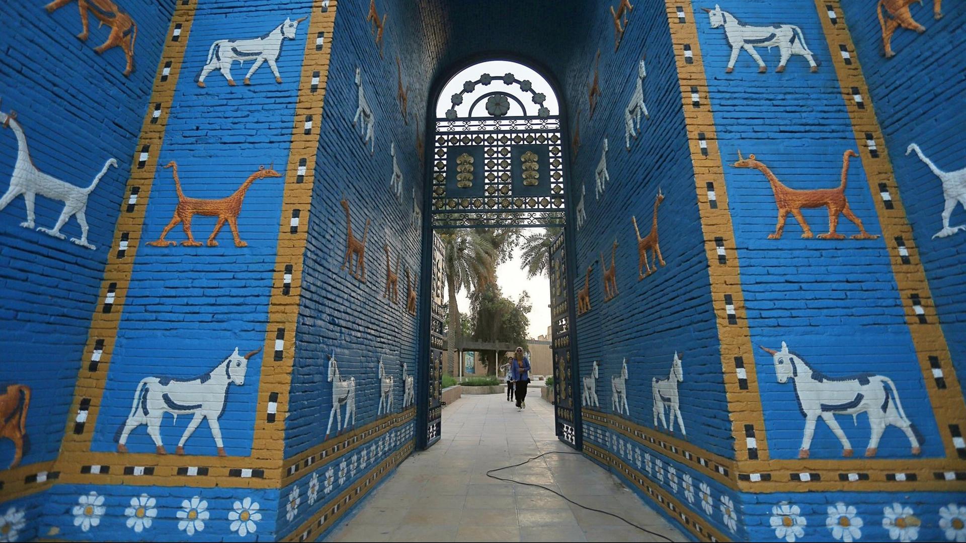 Besucher laufen durch den Nachbau des Ishtar-Tores in den Ruinen von Babylon.