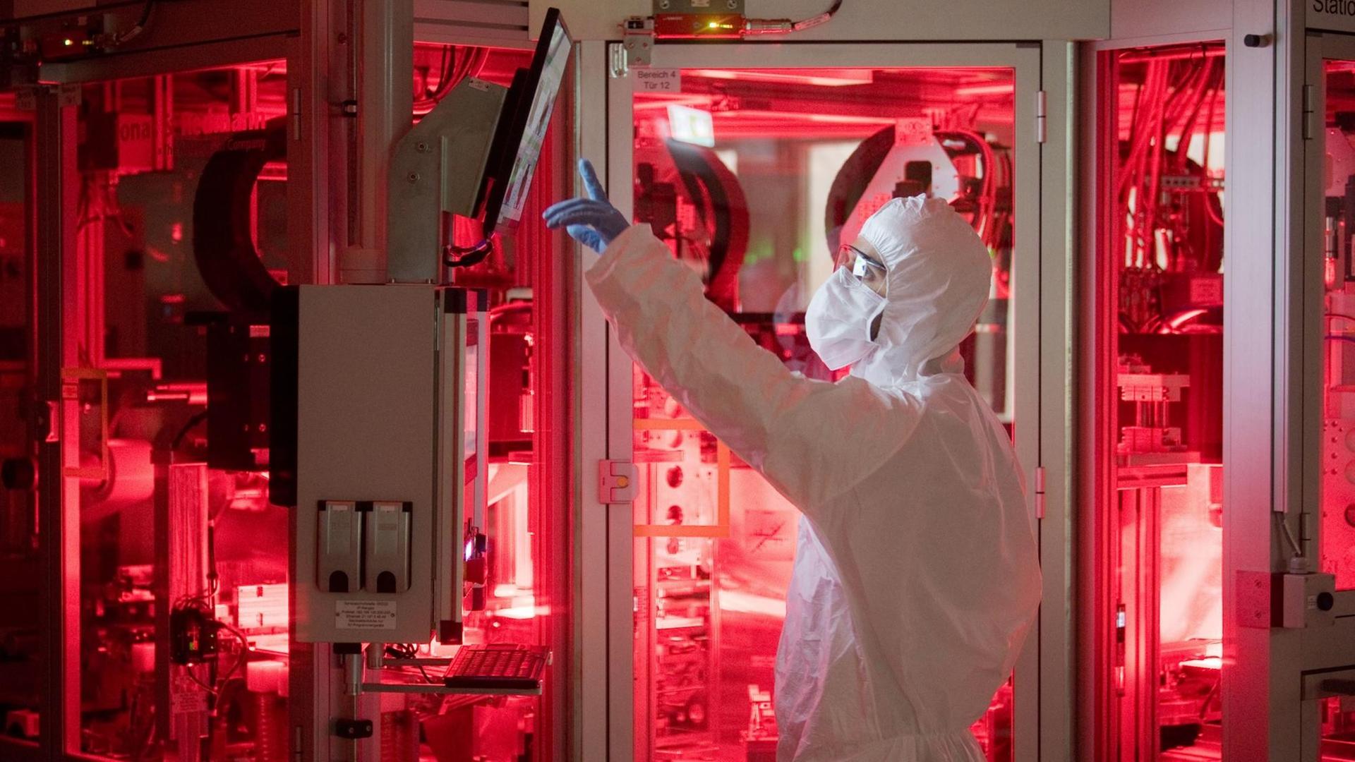 Ein Mitarbeiter von Volkswagen steht in einem Reinraum zur Produktion von Batteriezellen im VW Werk Salzgitter.