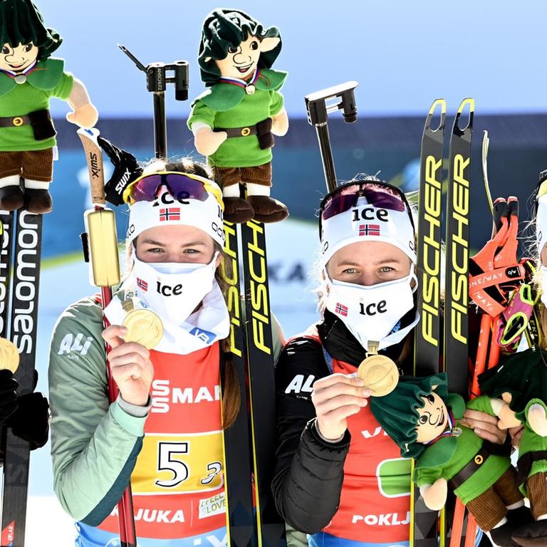 Die norwegischen Biathletinnen Marte Olsbu Roeiseland, Ida Lien, Tiril Eckhoff und Ingrid Landmark zeigen ihre Medaillen in die Kamera.