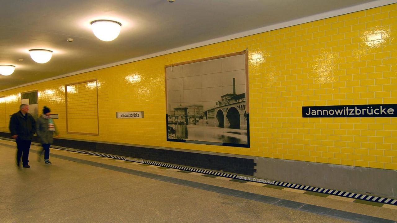 Das Gleis des U-Bahnhofs in dynamischer Ansicht. Die Kacheln an der Wand sind strahlend gelb.