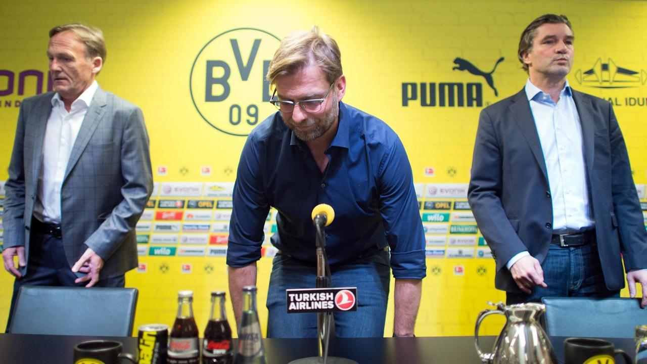 Der Dortmunder Trainer Jürgen Klopp gibt am 15. 4. 2015 auf einer Pressekonferenz vor den Vereinslogos seinen Rücktritt zum Saisonende bekannt. Links neben ihm ist Geschäftsführer Hans-Joachim Watzke zu sehen.