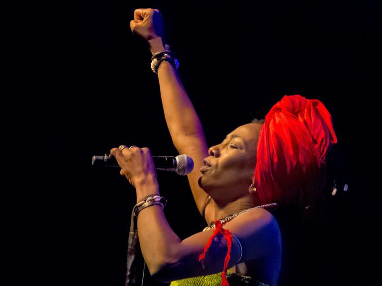 Sängerin Fatoumata Diawara aus Mali mit gestreckter Faust bei ihrem Auftritt im Berliner Huxleys im August 2018