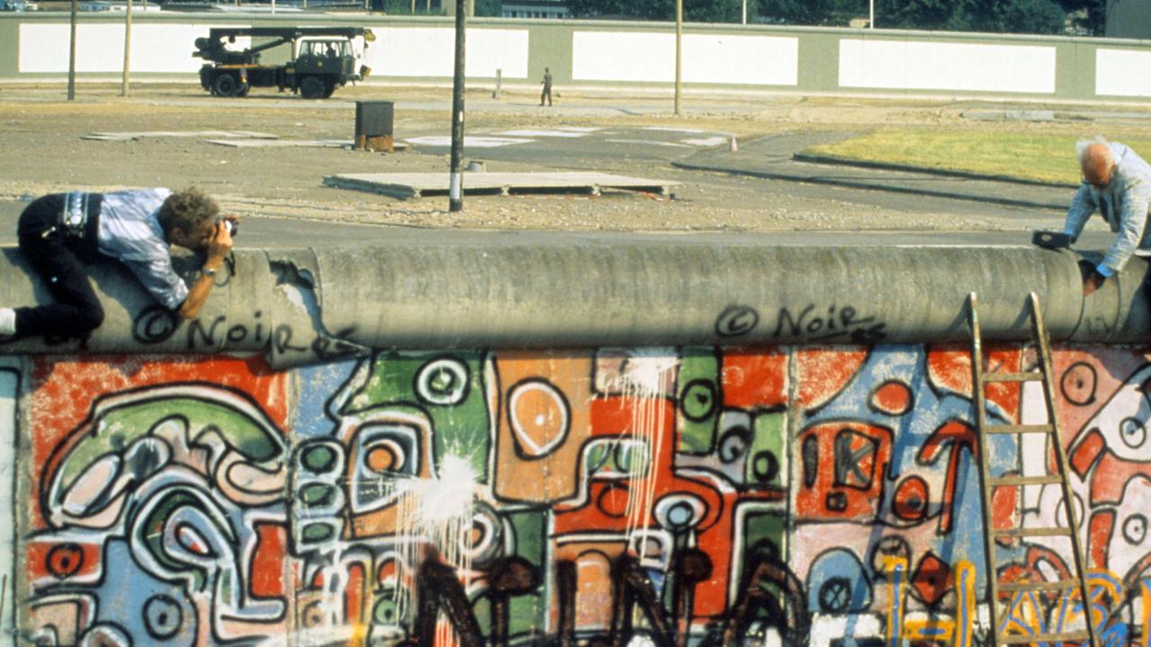 John Runnings demonstriert am 07.08.1986 mit einem Balanceakt gegen den Bau der Berliner Mauer vom 13. August 1961. Mit einem großen Vorschlaghammer führt der 69-jährige Amerikaner vor, was seiner Meinung nach mit dem Bauwerk zu tun sei.