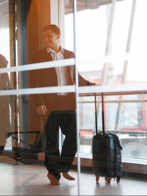 Ein Mann und eine Frau laufen am Flughafen Hamburg zu ihrem Gate (Illustration, Symbolbild)