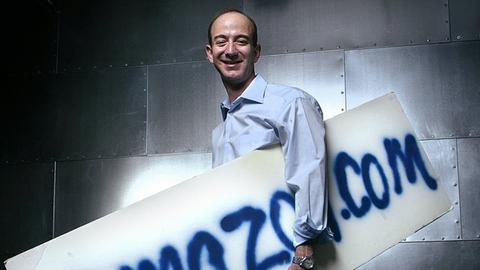Jeff Bezos 2004 mit dem ersten, von Hand gesprühten Amazon-Firmenschild von 1995