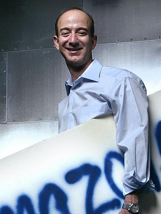 Jeff Bezos 2004 mit dem ersten, von Hand gesprühten Amazon-Firmenschild von 1995