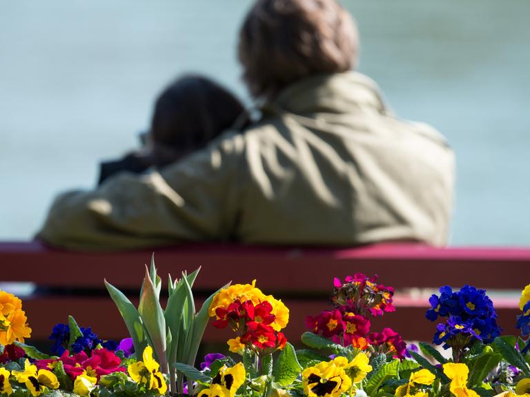 Ein Pärchen sitzt am 27.03.2014 in Passau (Bayern) auf einer Bank am Innufer.