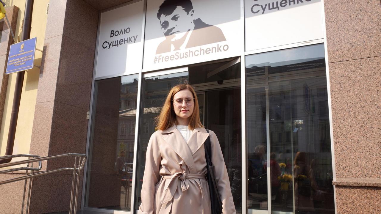 Julia Suschtschenko vor dem Gebäude der Nachrichtenagentur Ukrinform in Kiew, über deren Eingang ein Transparent mit der Aufschrift: "Freiheit für Suschtschenko". 
