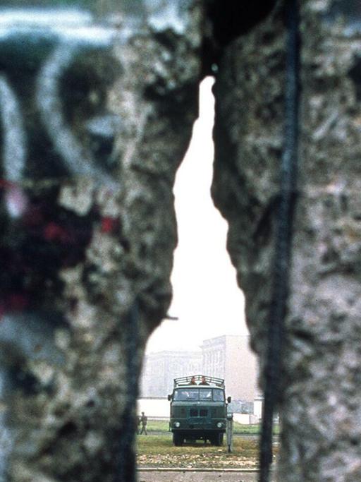 Zu sehen ist die Berliner Mauer, die ein Loch aufweist.