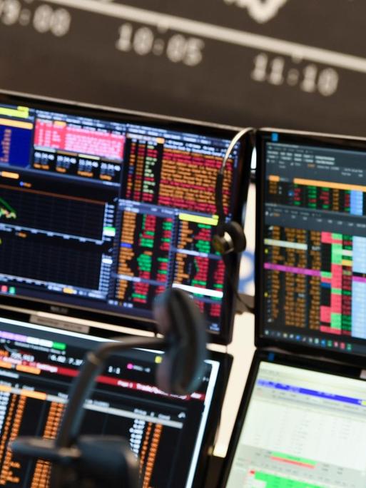Ein Aktienhändler beobachtet auf dem Parkett der Frankfurter Wertpapierbörse vor der Tafel mit der fallenden Dax-Kurve seine Monitore. Die sich verschärfende Corona-Krise mit schnell steigenden Infektionszahlen und einem drohenden «Lockdown» des öffentlichen Lebens in Deutschland haben den deutschen Aktienmarkt stark belastet.