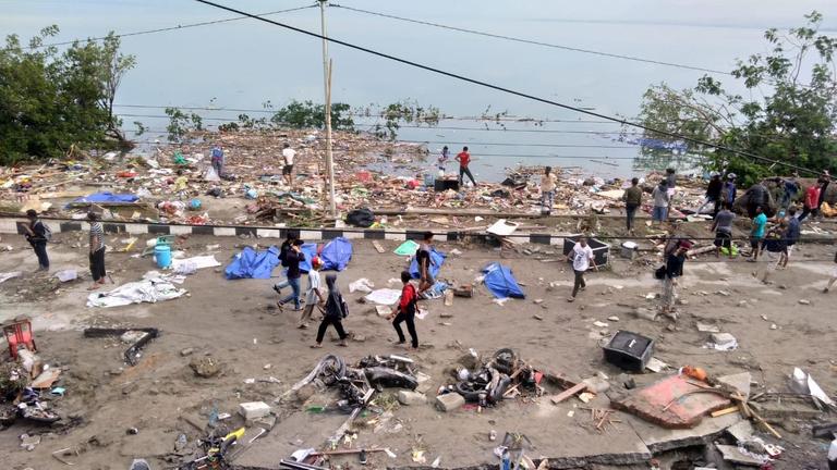 Zestörungen auf der indonesischen Insel Sulawesi am Tag nach dem Tsunami. Unter blauen Planen liegen Todesopfer. Zestörungen auf der indonesischen Insel Sulawesi am Tag nach dem Tsunami. Unter blauen Planen liegen Todesopfer.