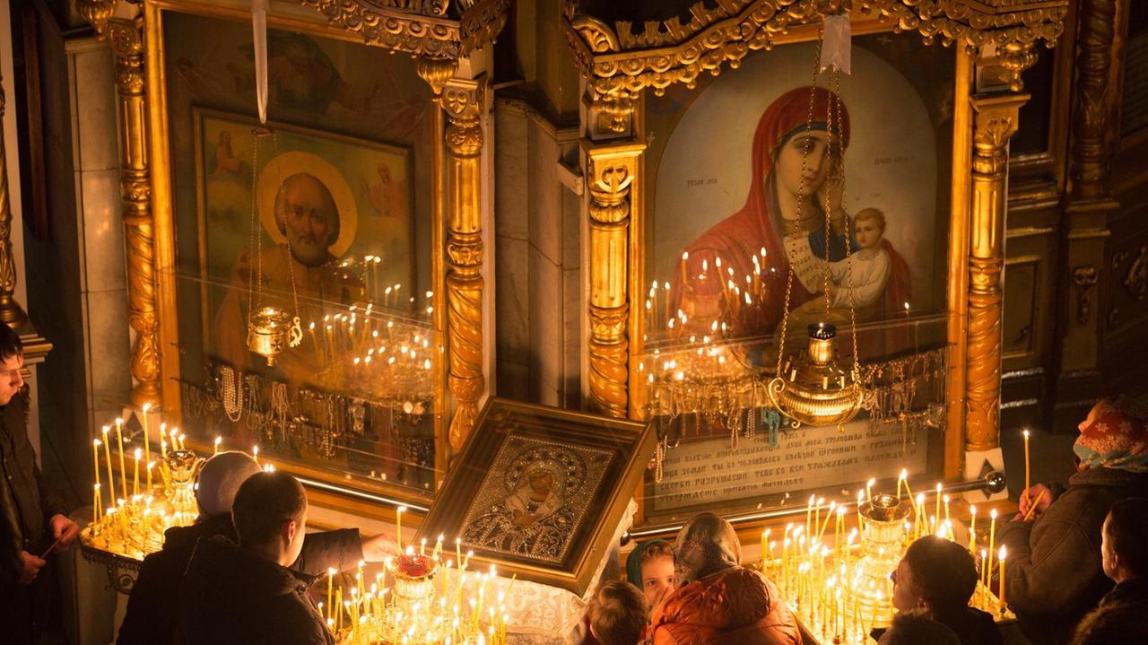 OMSK, RUSSIA. JANUARY 6, 2015. Russian Orthodox believers light candles during a Christmas liturgy at the Cathedral of the Exaltation of the Holy Cross in Omsk. The Russian Orthodox Church celebrates Christmas according to the Julian calendar. Dmitry Feoktistov/TASS |