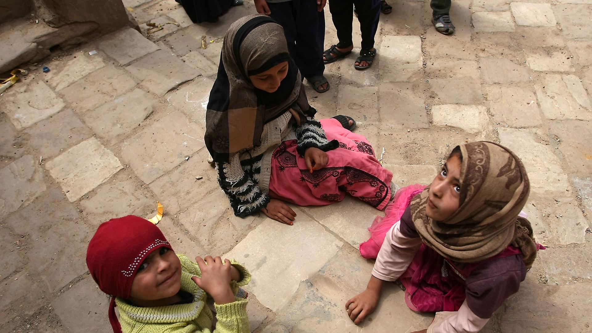 Kinder, die auf dem Boden sitzen, in Thula, 50 Kilometer entfernt von Sanaa.
