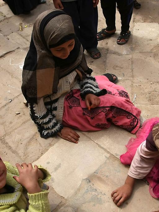 Kinder, die auf dem Boden sitzen, in Thula, 50 Kilometer entfernt von Sanaa.