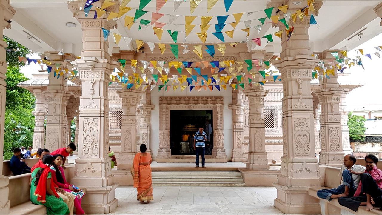 Ein Säulengang des Bhalka-Tirtha-Tempels im Westen Indiens ist mit blau-gelben Wimpeln geschmückt.