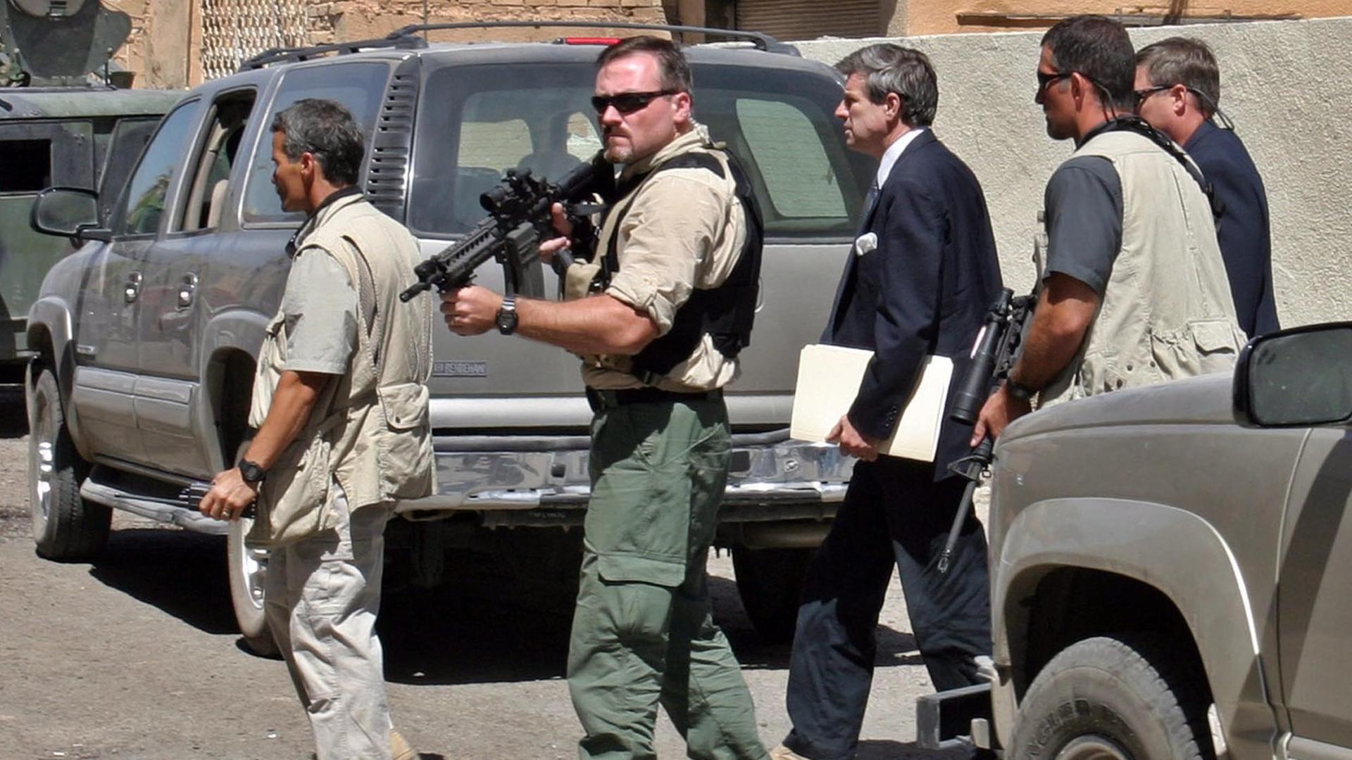 Mitarbeiter der privaten US-Sicherheitsfirma Blackwater schützen Paul Bremer, den ehemaligen zivilen US-Verwalter im Irak (Mitte), in Bagdad.