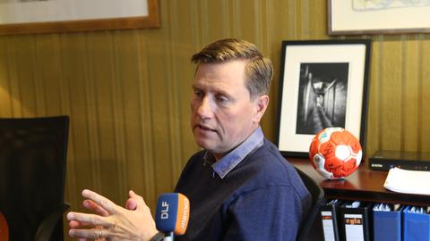 Guðmundur Ólafsson, Präsident des Isländischen Handballverbands HSI, spricht in ein Mikrofon.